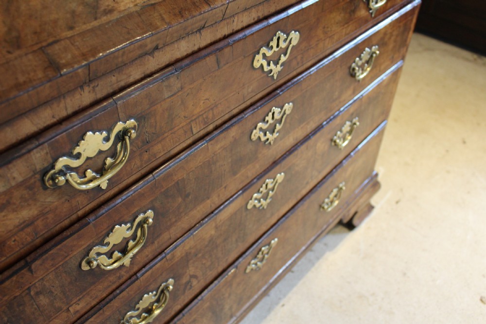 A George II walnut bureau featuring a slanted fall-front flap over four graduated drawers with brass handles, resting on bracket feet. View XIV