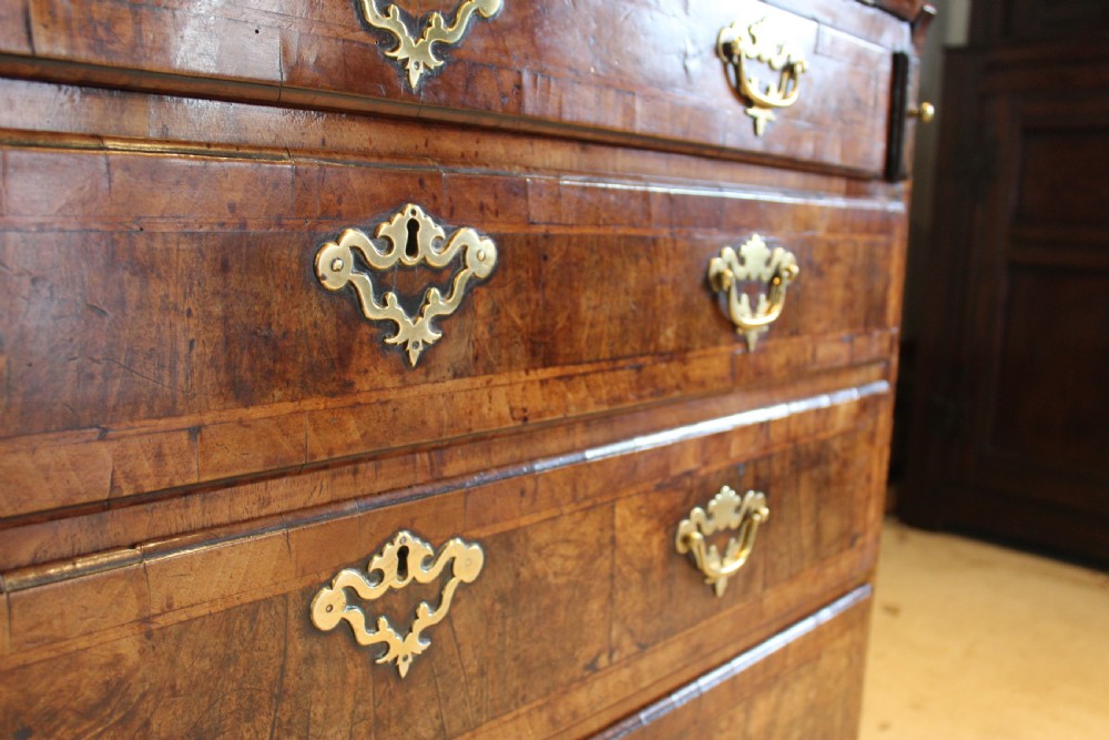 A George II walnut bureau featuring a slanted fall-front flap over four graduated drawers with brass handles, resting on bracket feet. View XV