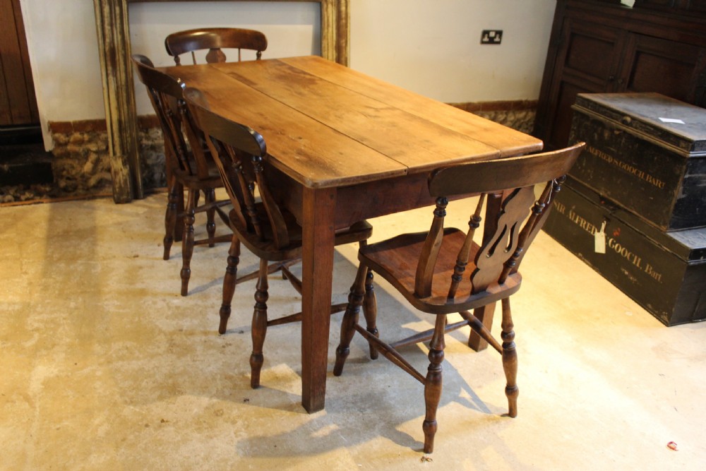A rectangular Victorian solid oak refectory dining table with a plank top and tapered square legs. View II