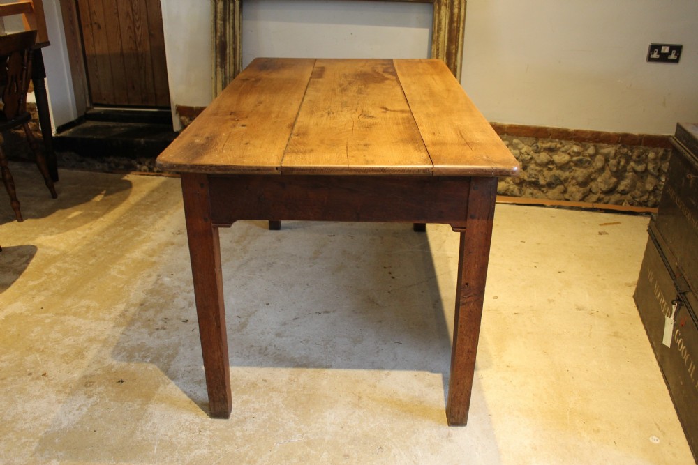 A rectangular Victorian solid oak refectory dining table with a plank top and tapered square legs. View III
