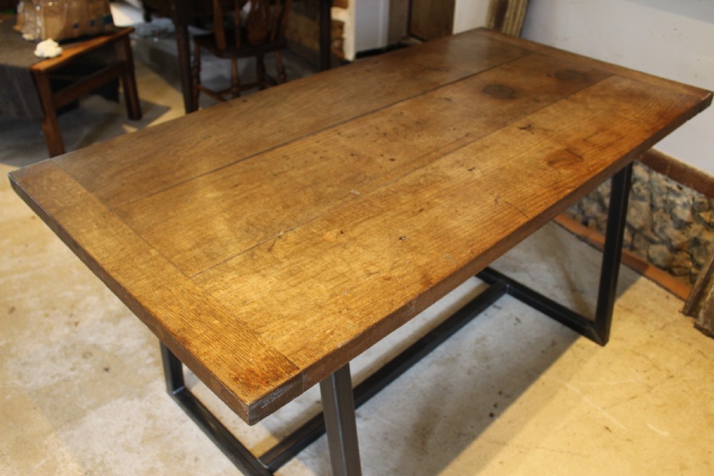 An antique George III oak plank table top with a warm brown patina mounted on a modern dark metal trapezoidal frame. View VI