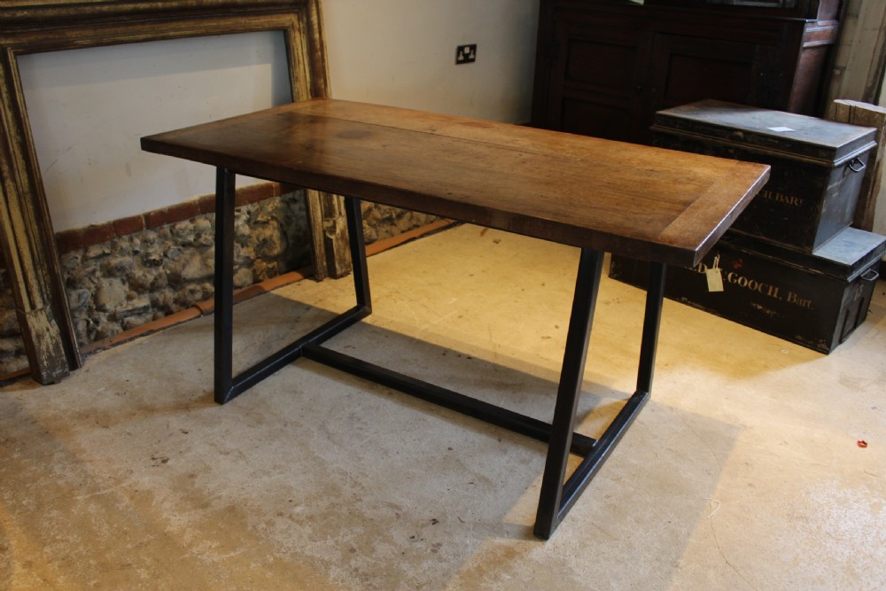 An antique George III oak plank table top with a warm brown patina mounted on a modern dark metal trapezoidal frame. View VII