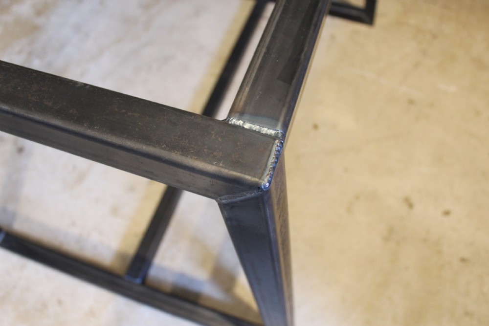 An antique George III oak plank table top with a warm brown patina mounted on a modern dark metal trapezoidal frame. View IX