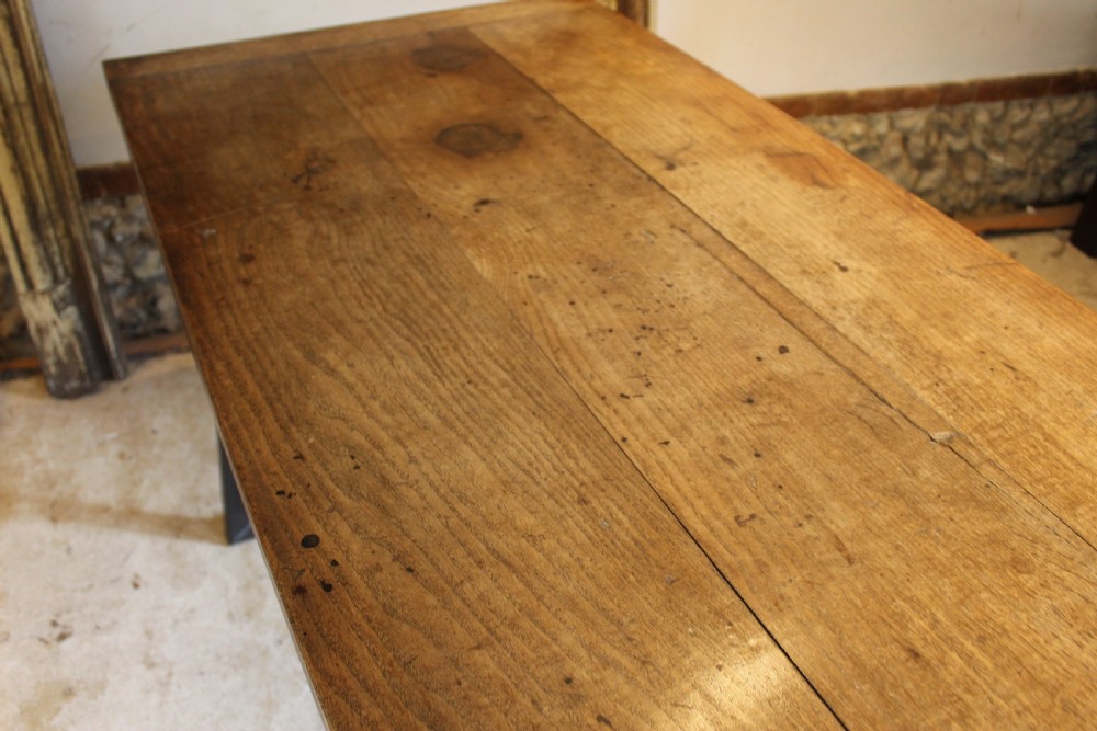 An antique George III oak plank table top with a warm brown patina mounted on a modern dark metal trapezoidal frame. View X