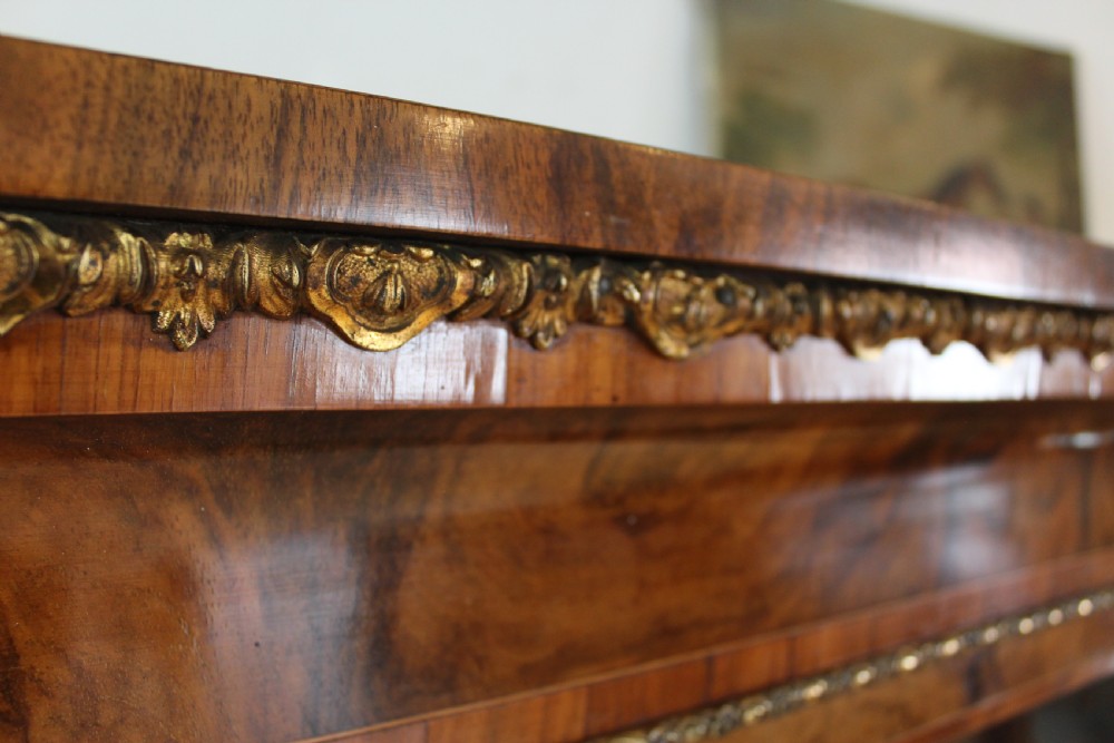 A pair of 19th-century Victorian walnut display cabinets featuring glazed single doors, adjustable interior shelves, and ornate gilt-bronze mounts on the corners and base. View XI
