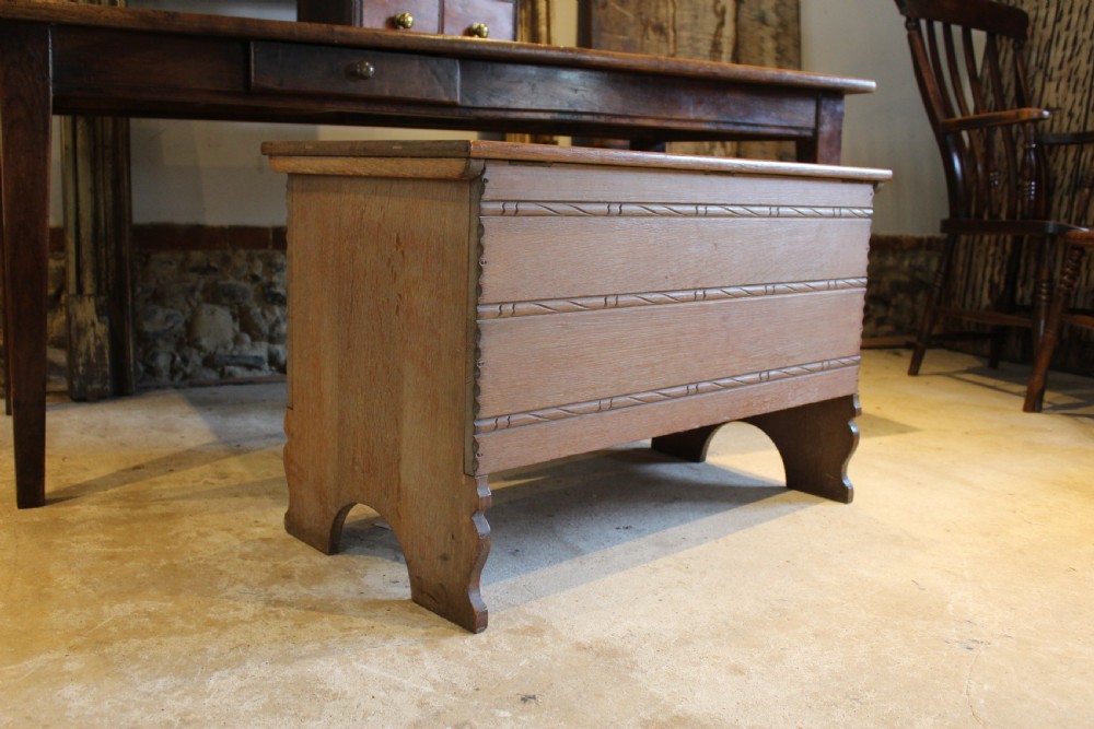 A 1930s limed oak coffer chest with carved horizontal rope twist detailing and cutout slab end feet.