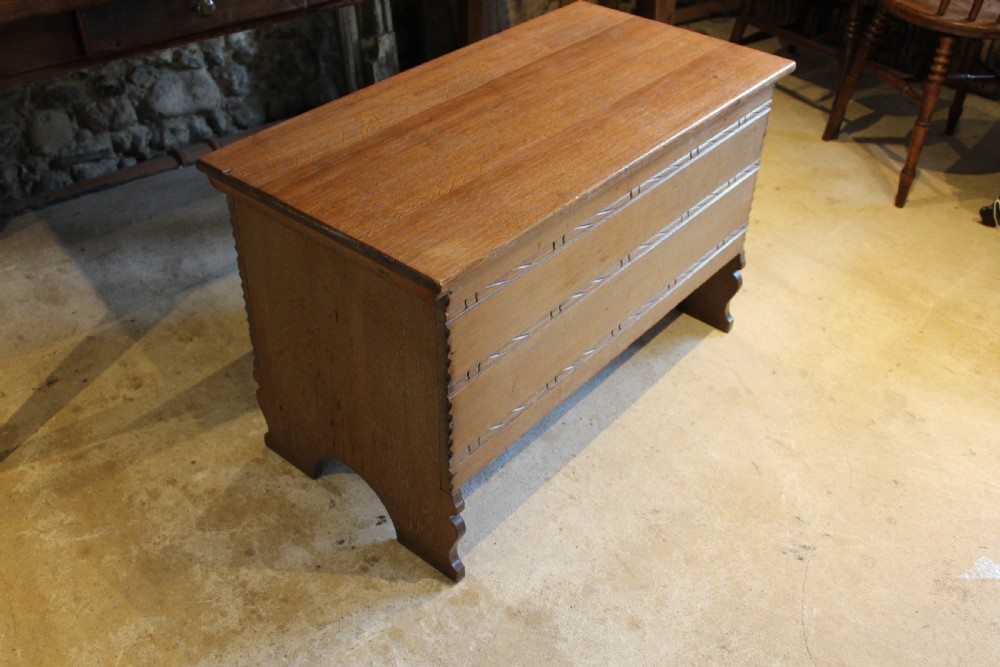 A 1930s limed oak coffer chest with carved horizontal rope twist detailing and cutout slab end feet. View IV