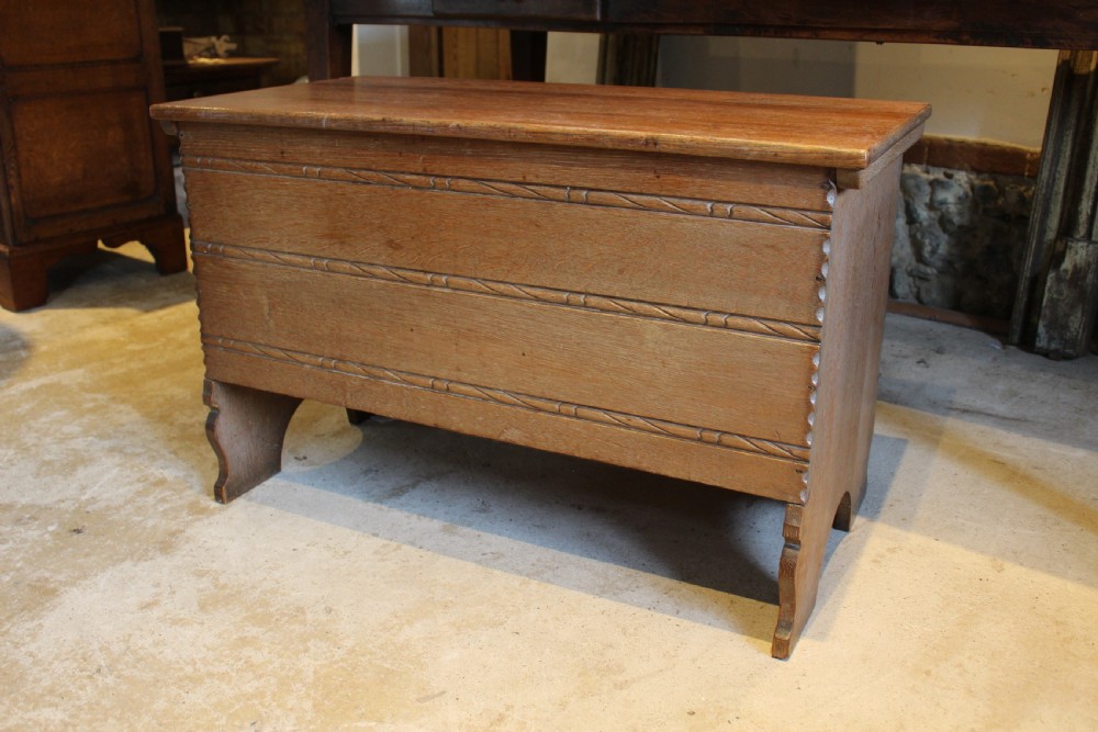 A 1930s limed oak coffer chest with carved horizontal rope twist detailing and cutout slab end feet. View VI
