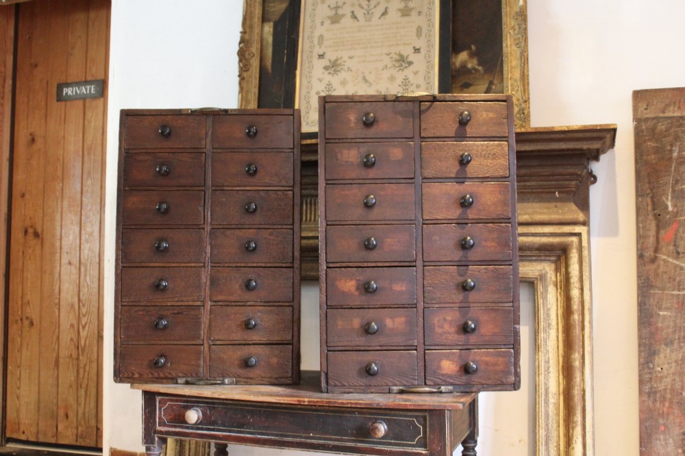 A pair of dark brown Victorian pine specimen cabinets, each featuring twin columns of eight small drawers fitted with turned wooden handles. View II