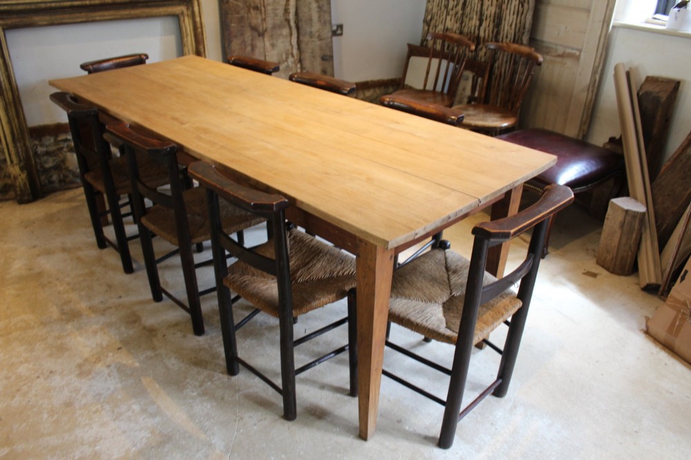 A long antique oak refectory dining table featuring a planked wood top and four square tapered legs. View II