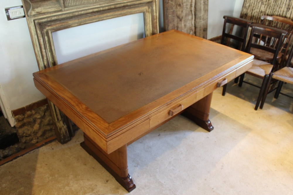 An Art Deco walnut desk featuring a rectangular top with an inset writing surface, frieze drawers with ribbed handles, and a trestle-style base with a low stretcher. View III