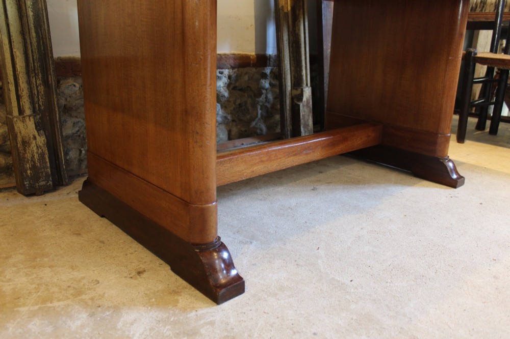 An Art Deco walnut desk featuring a rectangular top with an inset writing surface, frieze drawers with ribbed handles, and a trestle-style base with a low stretcher. View IV