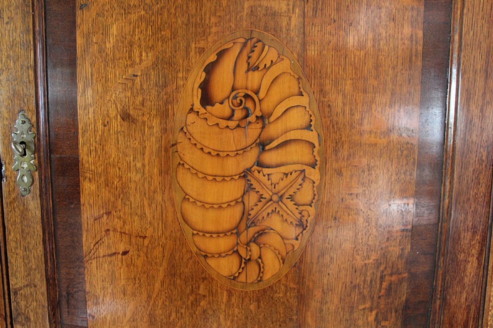 An 18th-century Georgian oak corner cupboard featuring a central inlaid shell motif on the single panel door and decorative crossbanding. View II