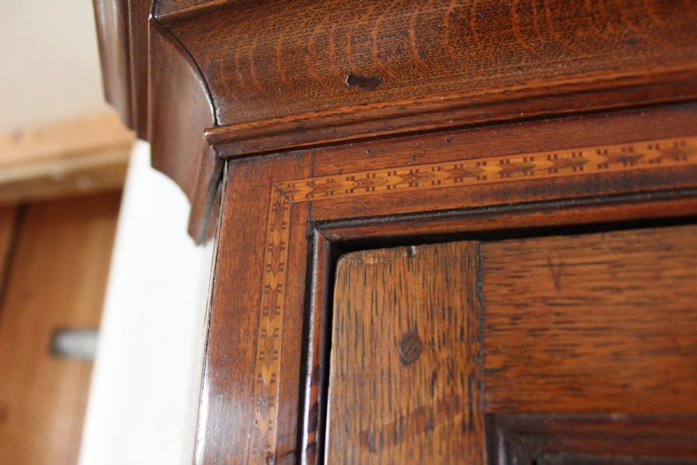 An 18th-century Georgian oak corner cupboard featuring a central inlaid shell motif on the single panel door and decorative crossbanding. View III