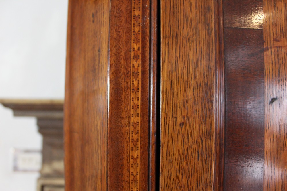 An 18th-century Georgian oak corner cupboard featuring a central inlaid shell motif on the single panel door and decorative crossbanding. View IX