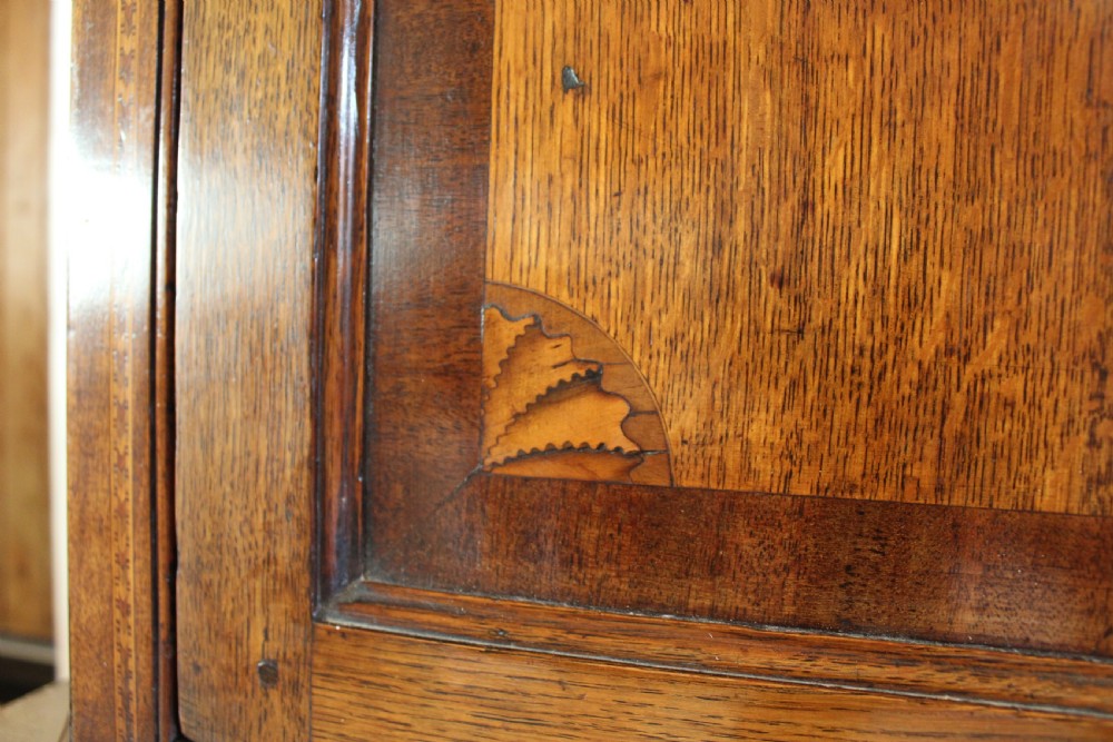 An 18th-century Georgian oak corner cupboard featuring a central inlaid shell motif on the single panel door and decorative crossbanding. View XI