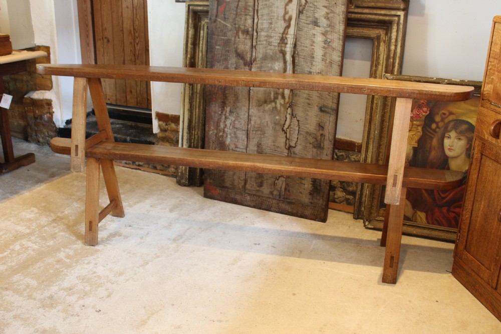A pair of long 19th-century French fruitwood refectory benches featuring A-frame trestle legs and pegged joinery. View VII
