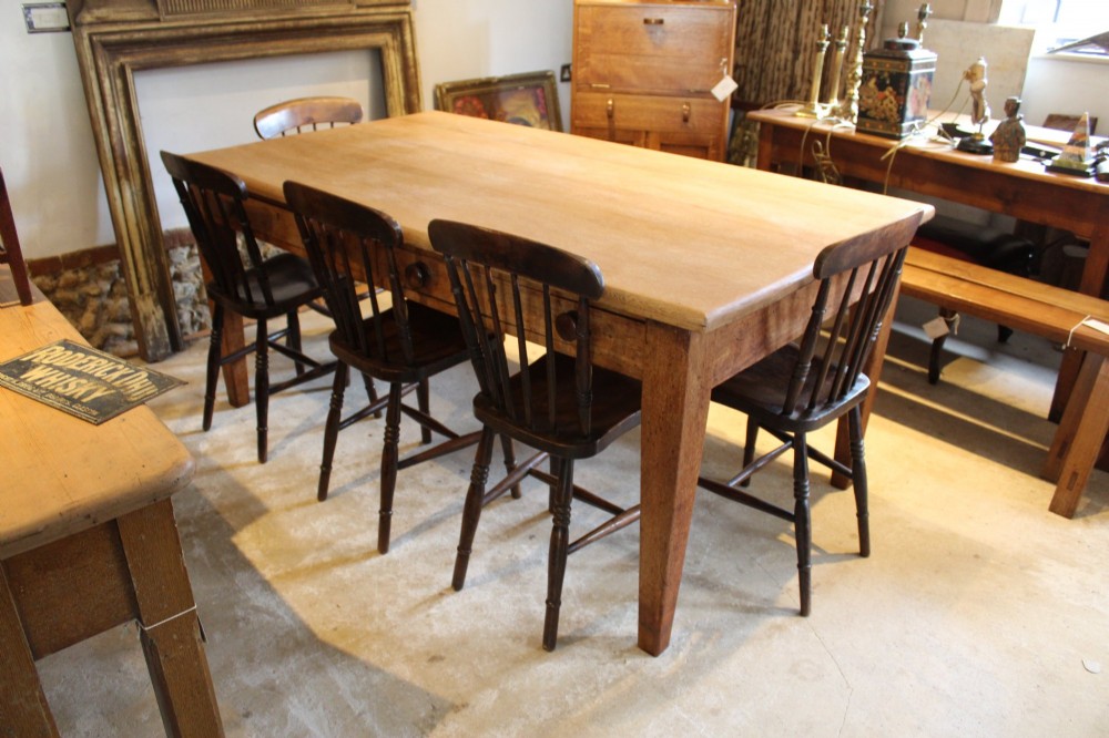 A late Victorian oak farmhouse dining table featuring a plain rectangular top, frieze drawers with wooden turned knobs, and square tapered legs. View II