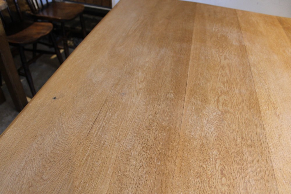 A late Victorian oak farmhouse dining table featuring a plain rectangular top, frieze drawers with wooden turned knobs, and square tapered legs. View IX