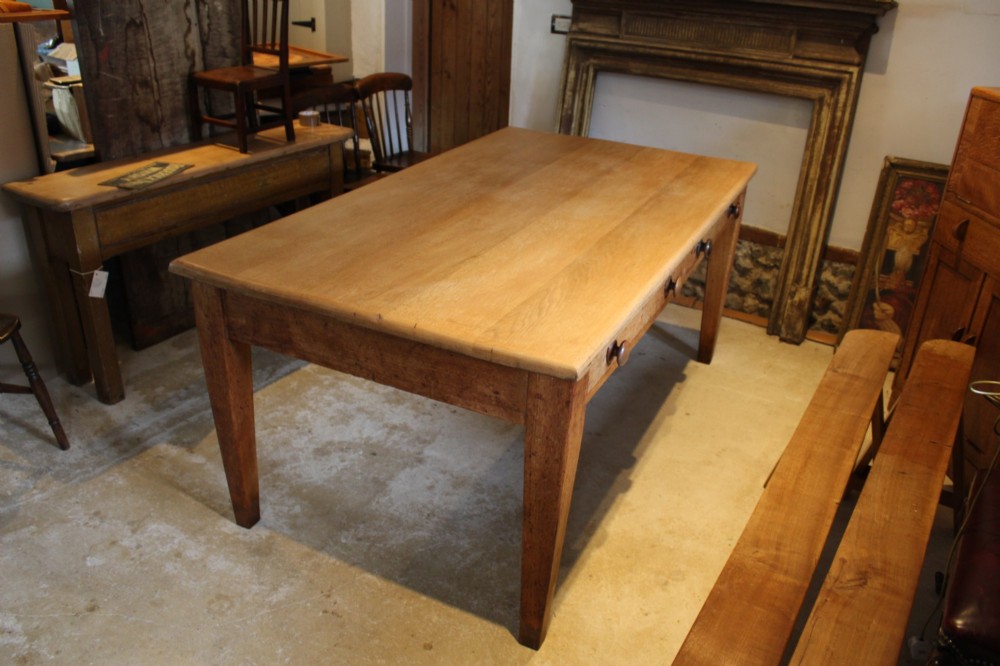 A late Victorian oak farmhouse dining table featuring a plain rectangular top, frieze drawers with wooden turned knobs, and square tapered legs. View X