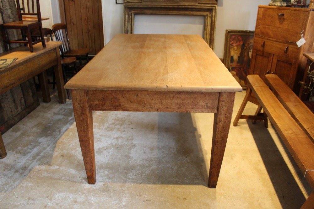 A late Victorian oak farmhouse dining table featuring a plain rectangular top, frieze drawers with wooden turned knobs, and square tapered legs. View XI