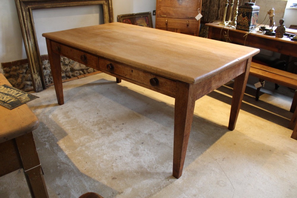 A late Victorian oak farmhouse dining table featuring a plain rectangular top, frieze drawers with wooden turned knobs, and square tapered legs. View XII