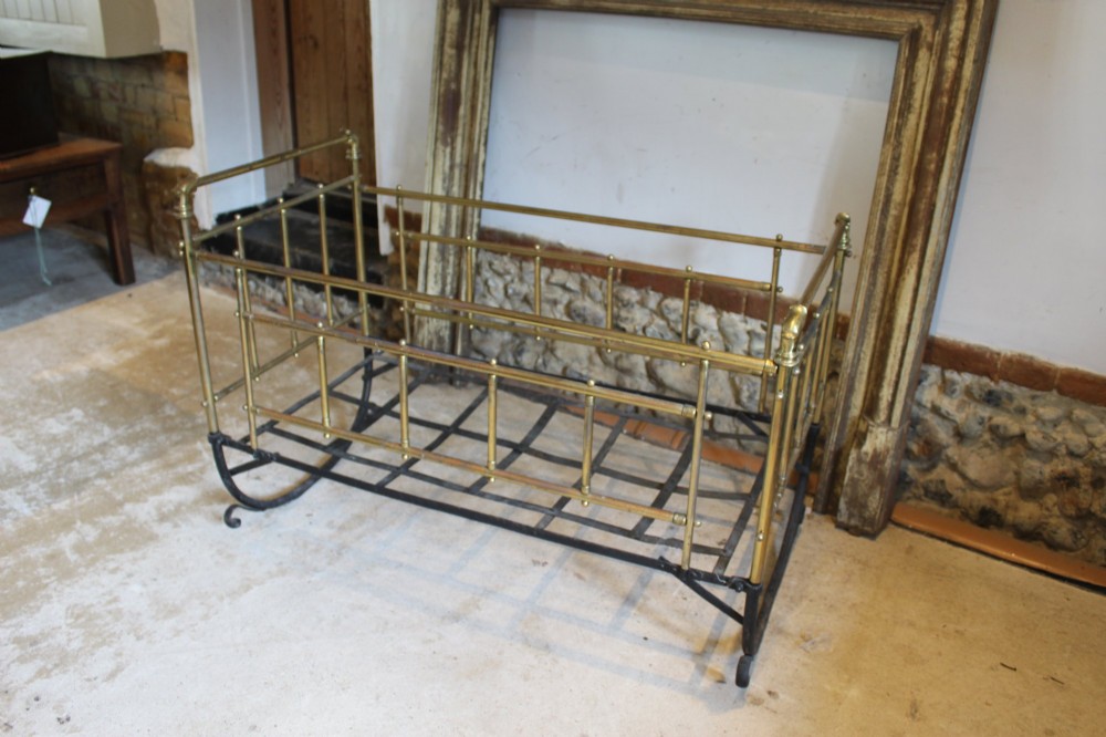 A Victorian brass and black wrought iron rocking cot featuring tubular side rails, finial accents, and a curved iron base. View III