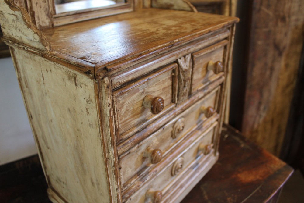 A late 19th-century French miniature wooden chest of drawers featuring a painted distressed cream finish, small turned wooden knobs, and an attached swivel mirror. View III