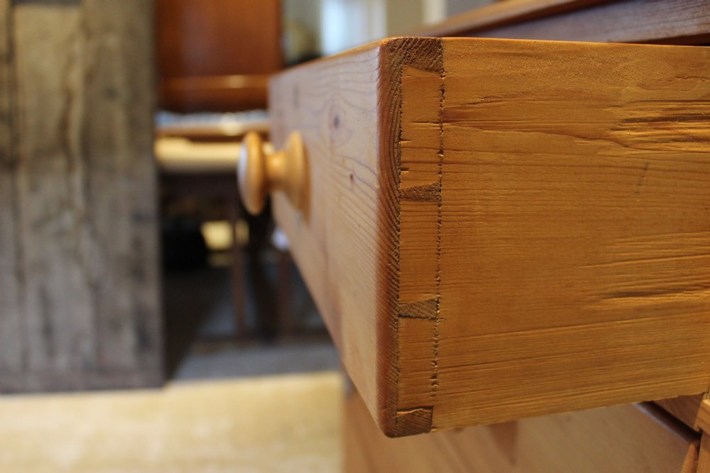 A Victorian pine chest of drawers featuring two short drawers over three long drawers with turned wooden handles and turned bun feet. View III
