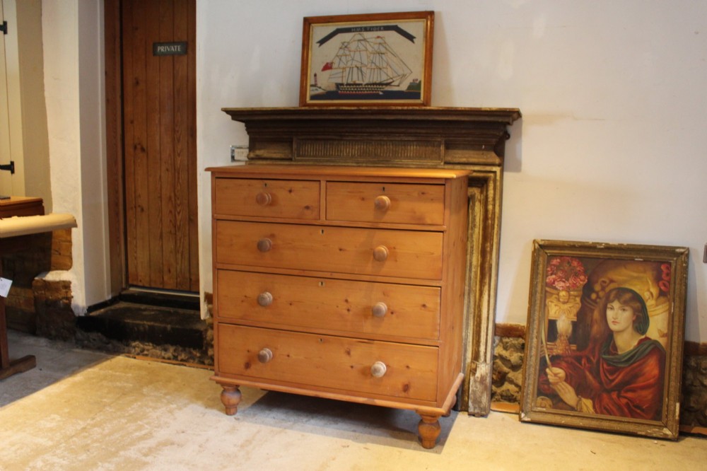 A Victorian pine chest of drawers featuring two short drawers over three long drawers with turned wooden handles and turned bun feet. View IX