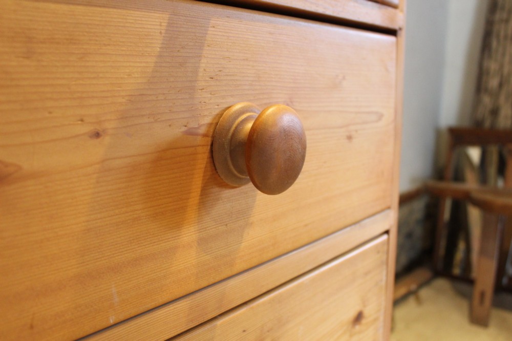 A Victorian pine chest of drawers featuring two short drawers over three long drawers with turned wooden handles and turned bun feet. View X