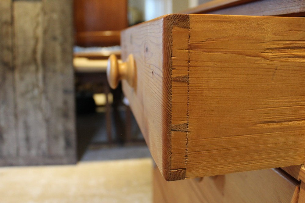 A Victorian pine chest of drawers featuring two short drawers over three long drawers with turned wooden handles and turned bun feet. View XI