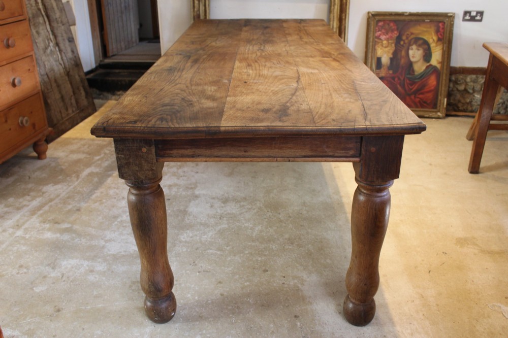 A large Edwardian oak refectory dining table with a rectangular plank top and sturdy turned legs. View II