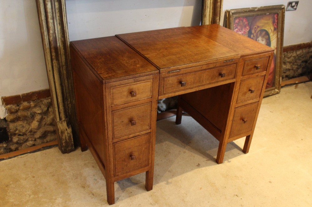 An antique golden oak dressing table featuring a central flip-top section, side drawer pedestals, and square wooden handles. View II