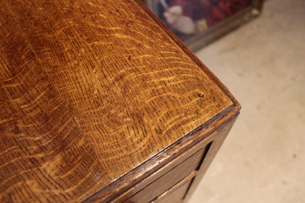 An antique golden oak dressing table featuring a central flip-top section, side drawer pedestals, and square wooden handles. View III