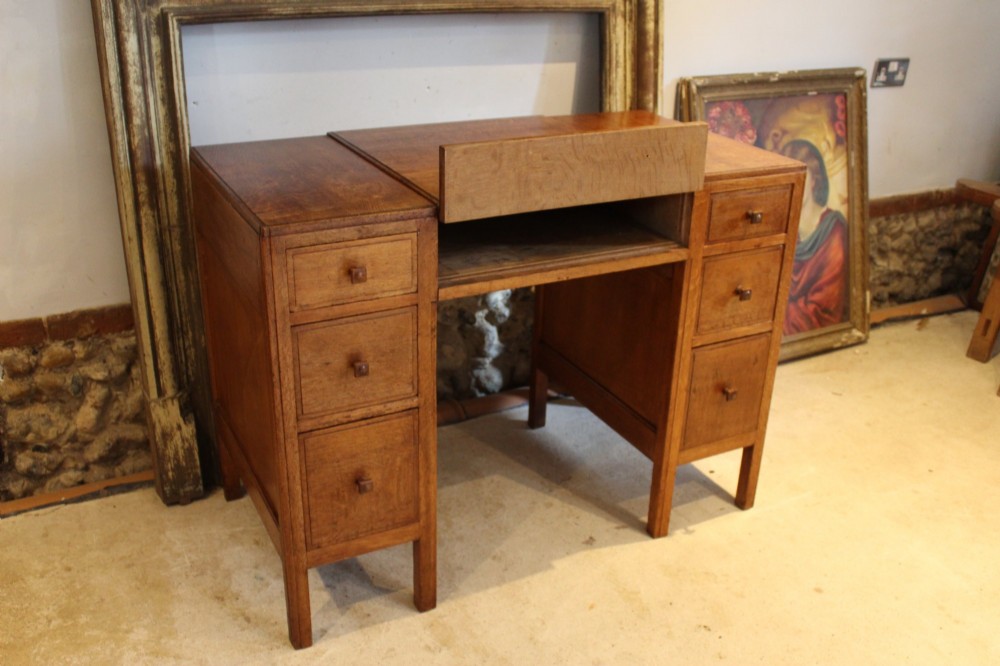 An antique golden oak dressing table featuring a central flip-top section, side drawer pedestals, and square wooden handles. View VI