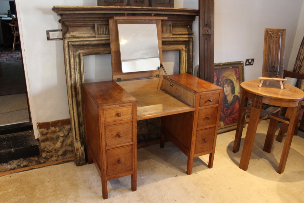 An antique golden oak dressing table featuring a central flip-top section, side drawer pedestals, and square wooden handles. View VII