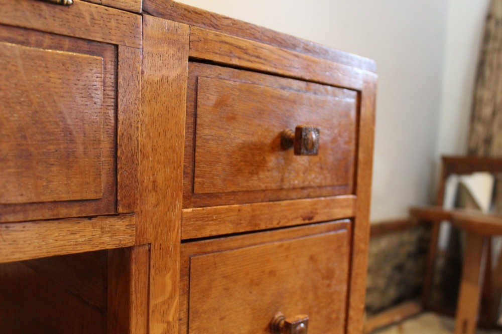 An antique golden oak dressing table featuring a central flip-top section, side drawer pedestals, and square wooden handles. View XII