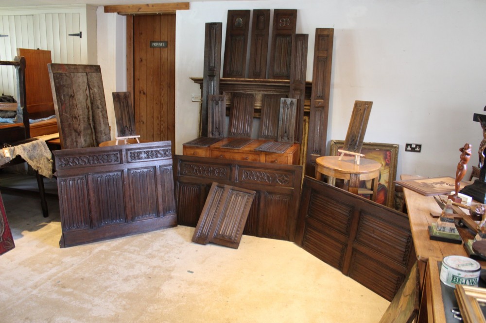 A collection of 16th and 17th-century carved oak panels displaying intricate linenfold and Gothic tracery relief motifs in dark brown tones.