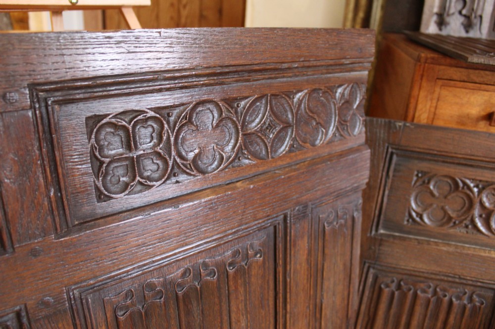 A collection of 16th and 17th-century carved oak panels displaying intricate linenfold and Gothic tracery relief motifs in dark brown tones. View III