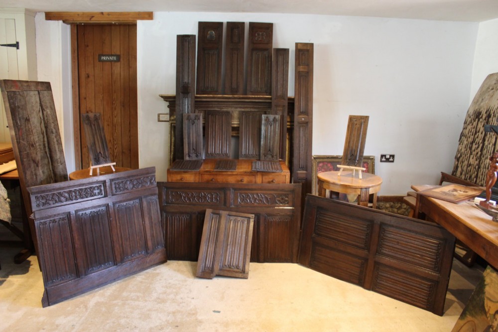 A collection of 16th and 17th-century carved oak panels displaying intricate linenfold and Gothic tracery relief motifs in dark brown tones. View VI