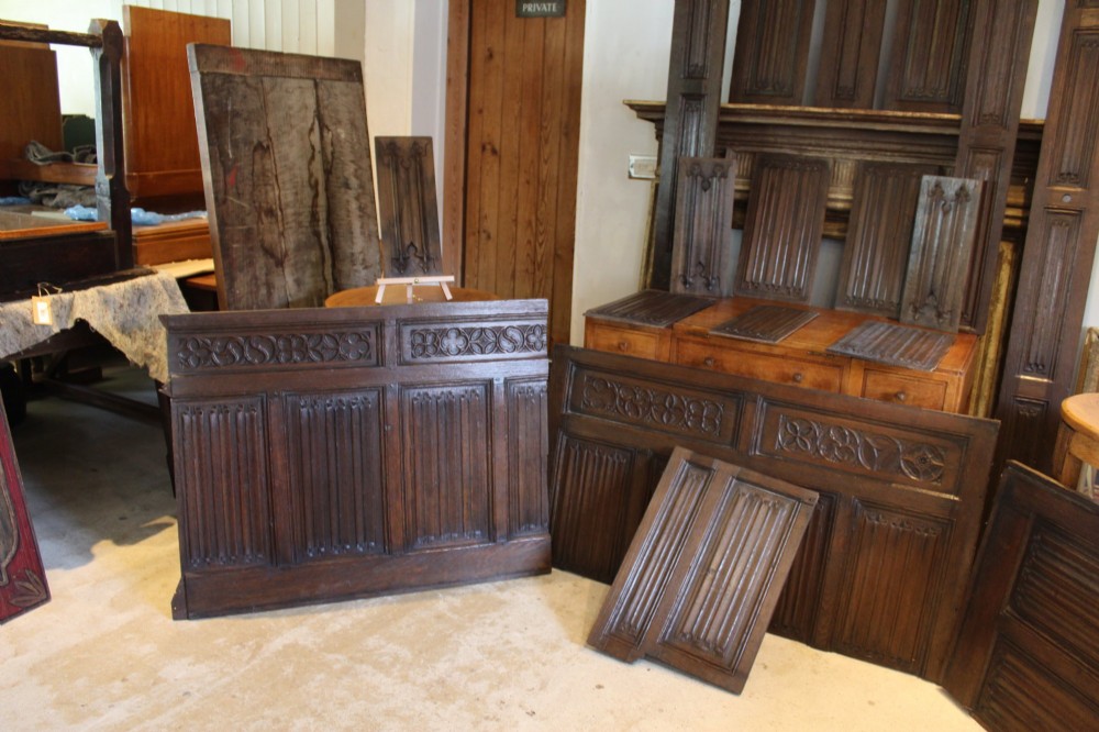 A collection of 16th and 17th-century carved oak panels displaying intricate linenfold and Gothic tracery relief motifs in dark brown tones. View VIII