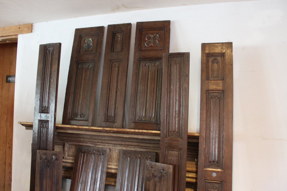 A collection of 16th and 17th-century carved oak panels displaying intricate linenfold and Gothic tracery relief motifs in dark brown tones. View IX