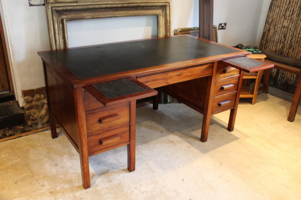 An Art Deco walnut pedestal desk featuring a black leather inset top, a central drawer, and six side drawers with wooden bar handles. View II