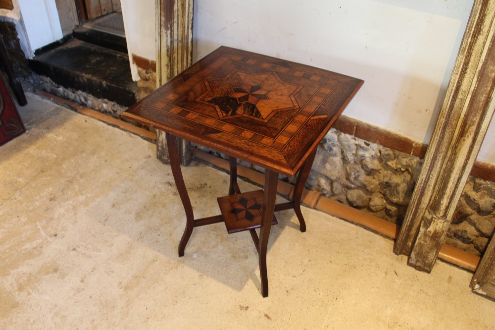 A square Victorian side table featuring geometric star-patterned specimen wood marquetry, curved legs, and a matching central undertier. View VIII
