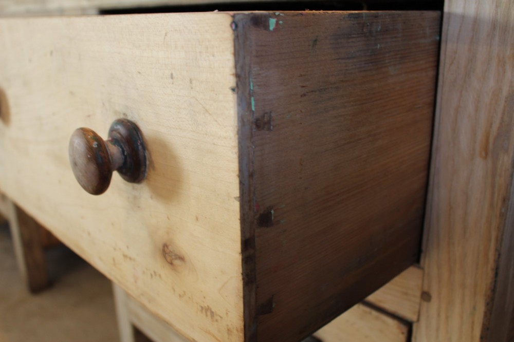 A George III scrubbed pine kneehole desk featuring four side drawers with turned wood handles and an arched central opening. View VIII