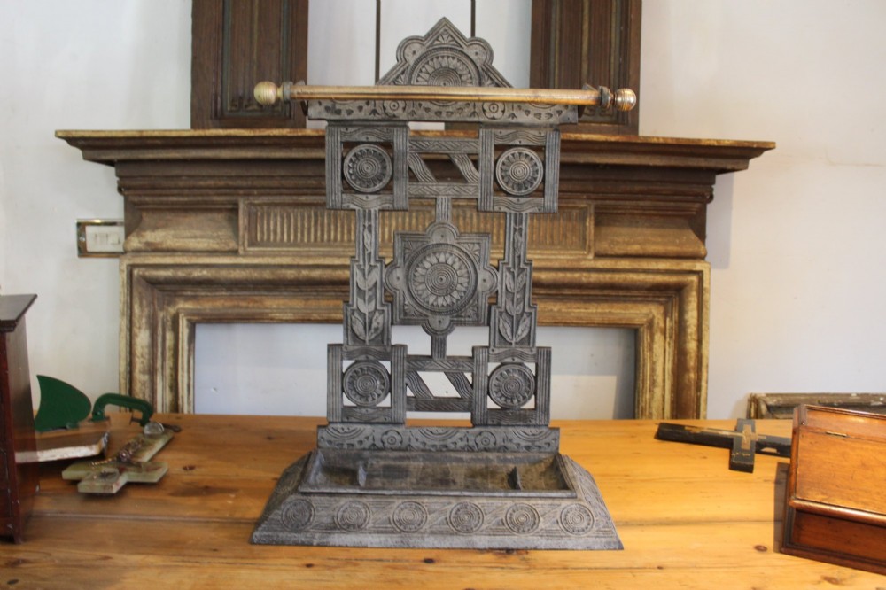 A Victorian cast iron stick stand featuring intricate geometric lattice patterns, a central floral rosette medallion, and a brass top rail over a rectangular drip tray. View IV