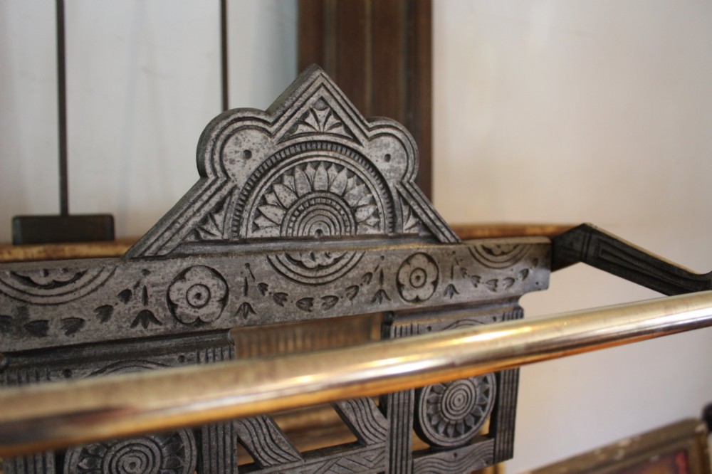 A Victorian cast iron stick stand featuring intricate geometric lattice patterns, a central floral rosette medallion, and a brass top rail over a rectangular drip tray. View IX