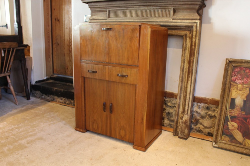 An Art Deco walnut bureau featuring a fall-front writing compartment above a single drawer and a two-door cupboard. View II