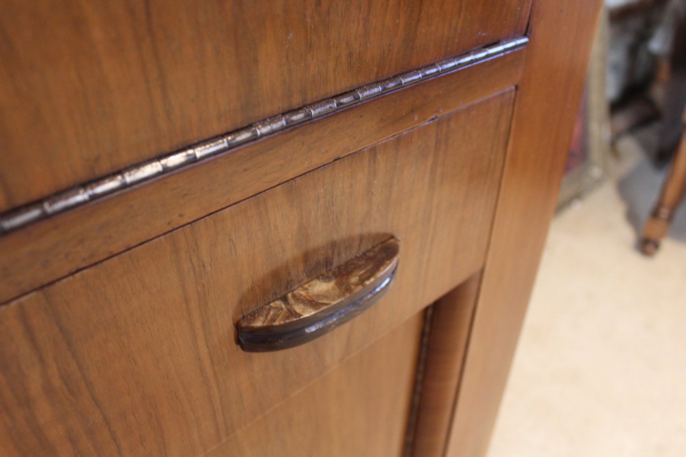 An Art Deco walnut bureau featuring a fall-front writing compartment above a single drawer and a two-door cupboard. View III